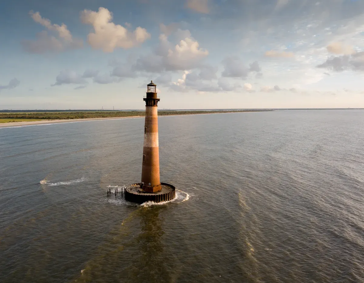 Morris Island Lighthouse standing offshore, seen on the Lighthouse Inlet walk or a cruise from Charleston SC
