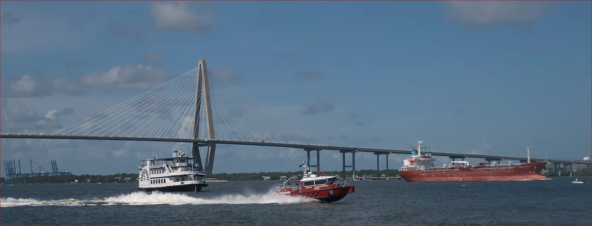 Boats on Charleston Harbor under the Ravenel Bridge, the water a party boat in Charleston cruises